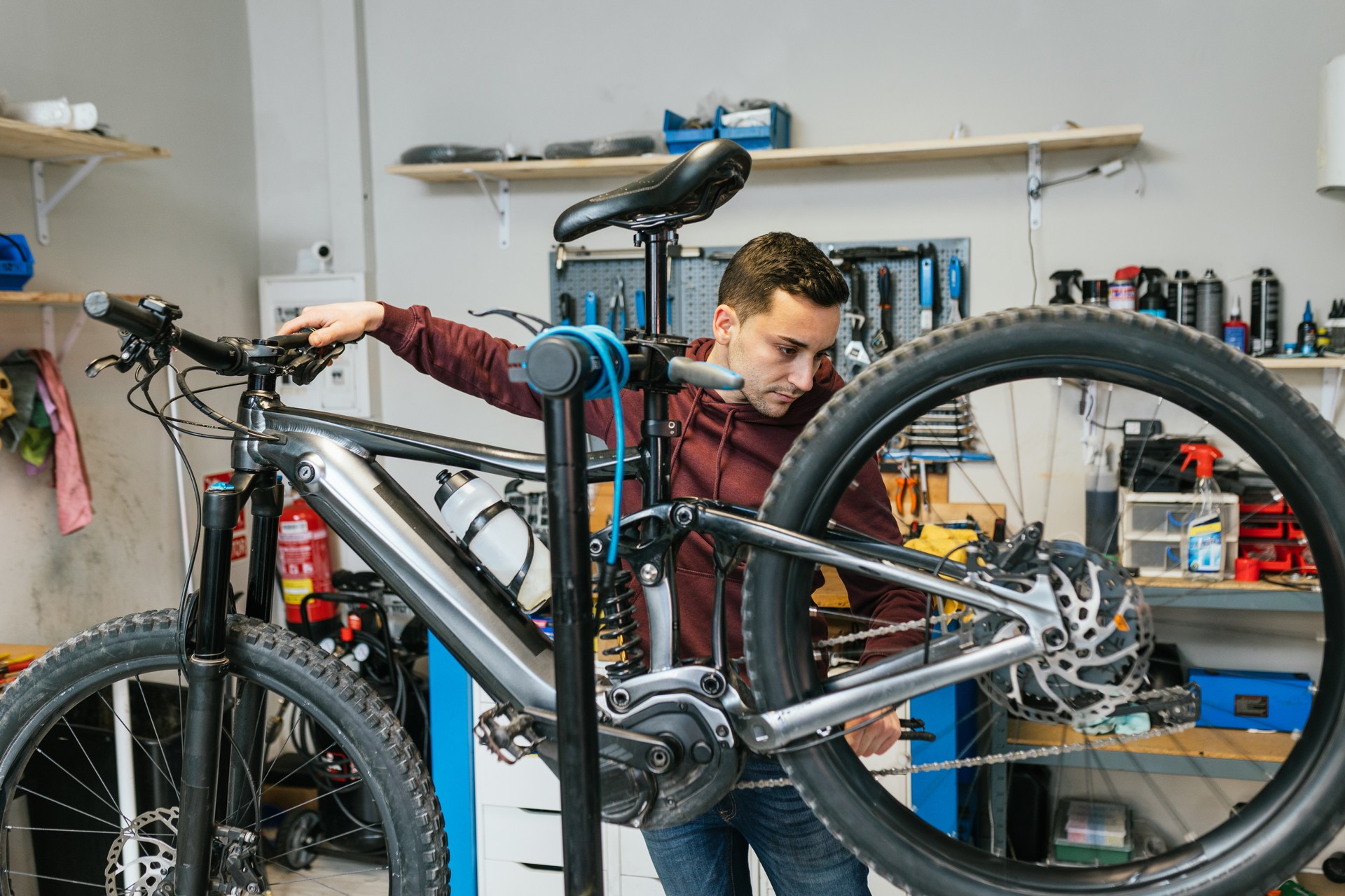 Bike mechanic testing the rear gear shift and brakes of a mountain bike