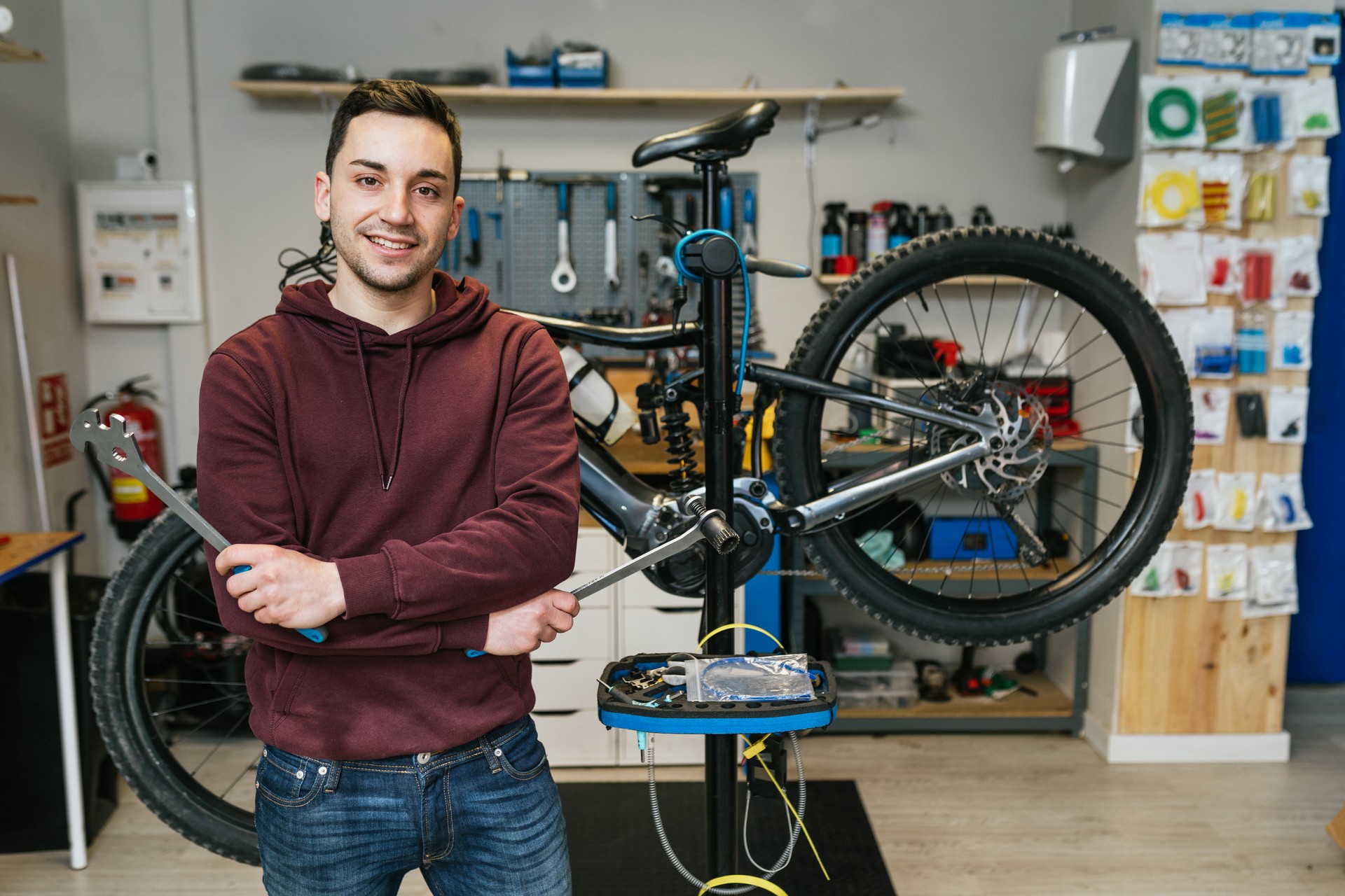 A bike mechanic standing in front of his bicycle at the bike shop