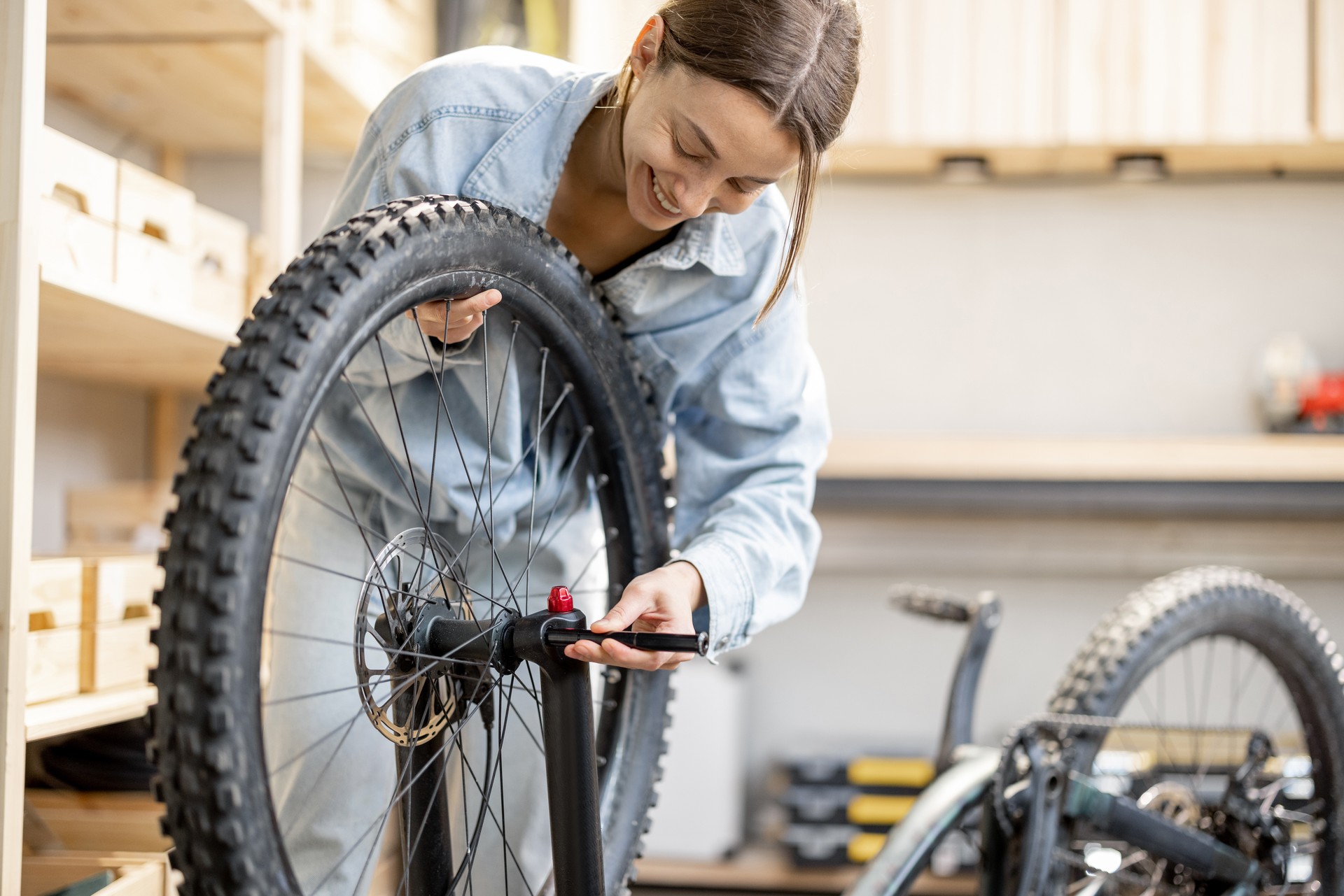 Handywoman reparing bicycle in the workshop